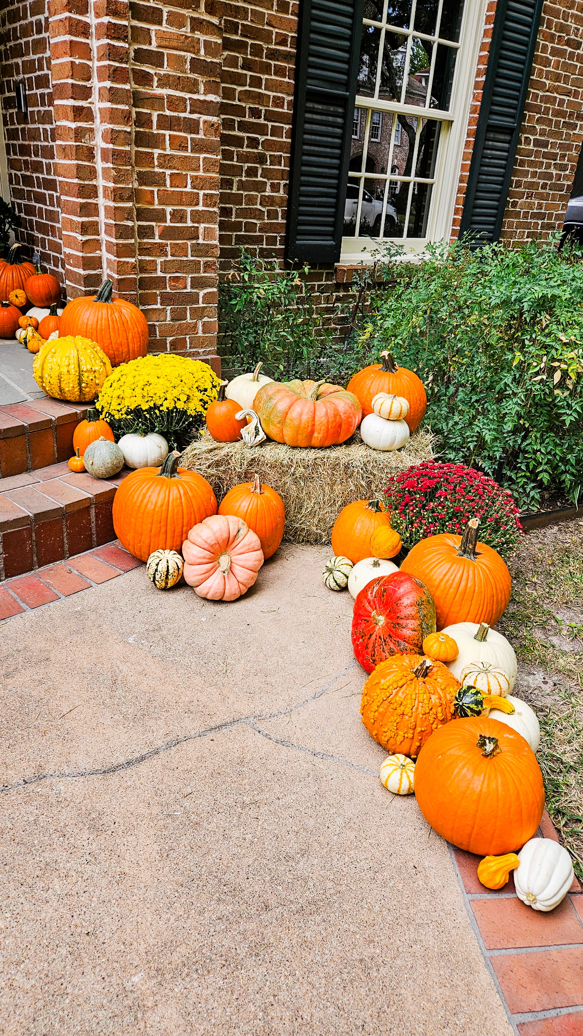 pumpkin decoration ideas on fall porch with hay bales and colorful pumpkins